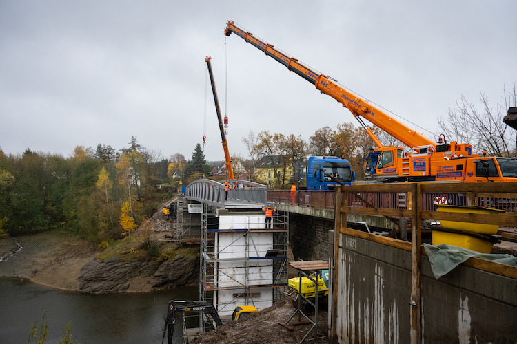 Cranes position the aluminum bridge