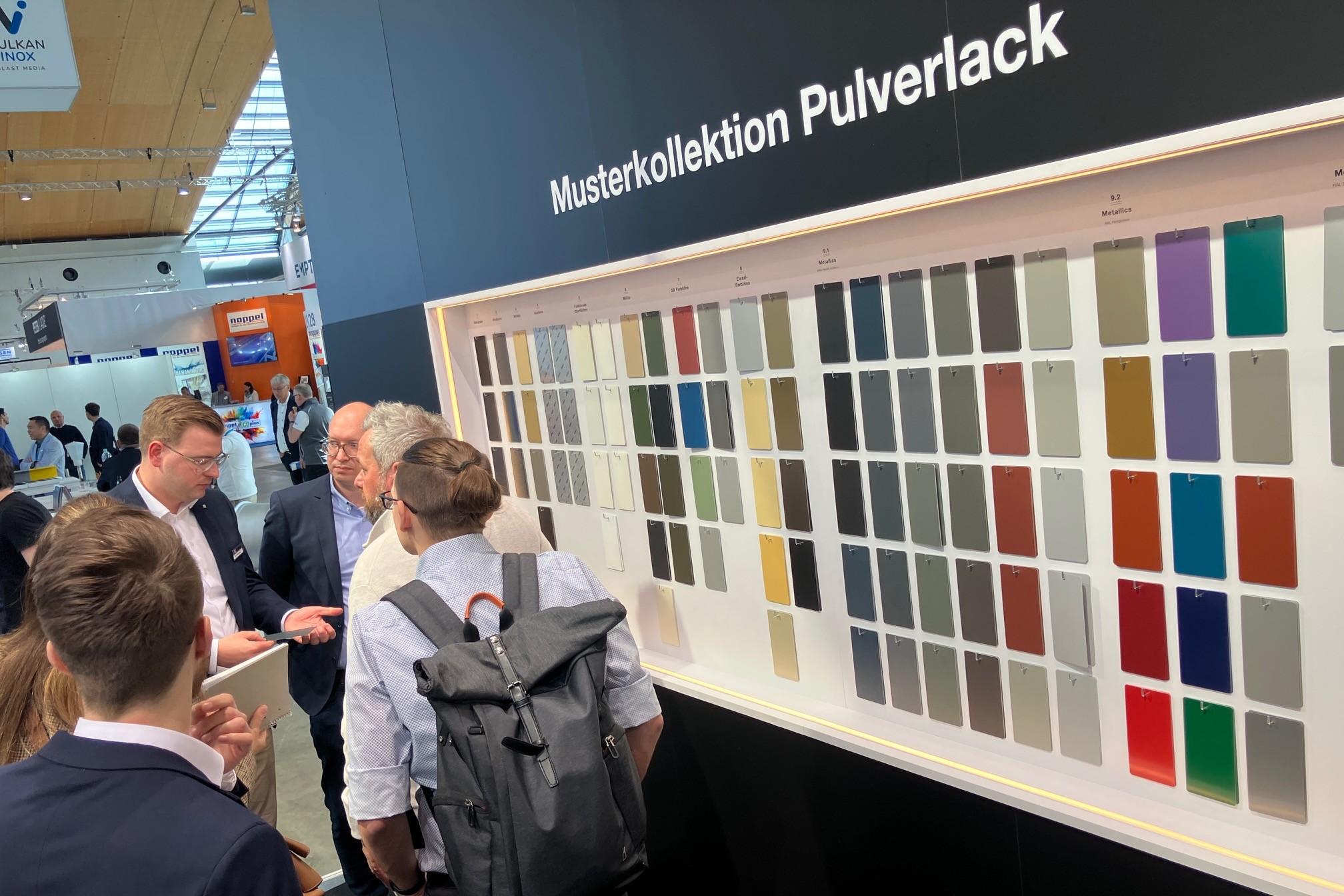 Wand mit der Musterkollektion Pulverlack auf dem Messestand